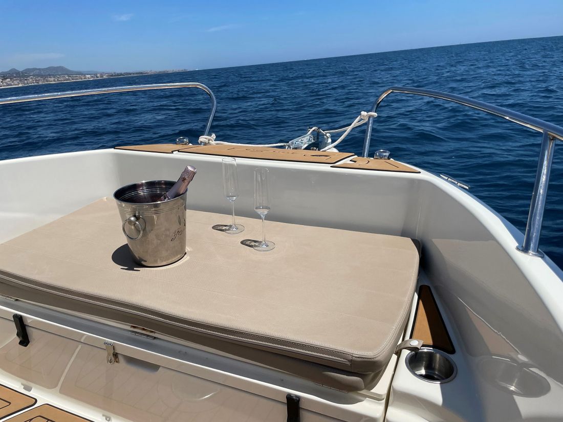 Vista de cubitera con botella de champange y dos copas en interior de lancha AndSol